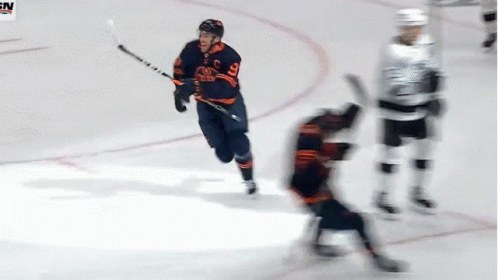 A Hockey Player With The Number 9 On His Jersey Is Holding A Stick GIF