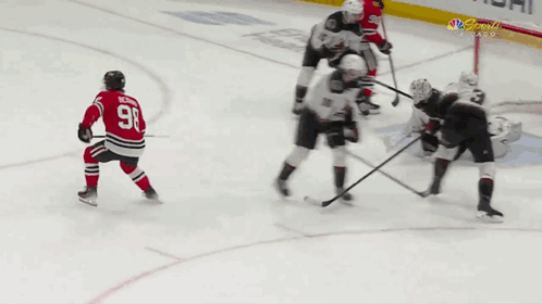 A Hockey Player With The Number 98 On His Jersey Is Kneeling On The Ice GIF