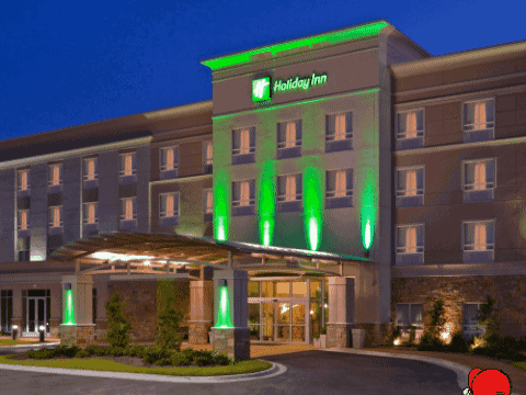 A Holiday Inn Hotel With Green Lights On The Front Of It GIF