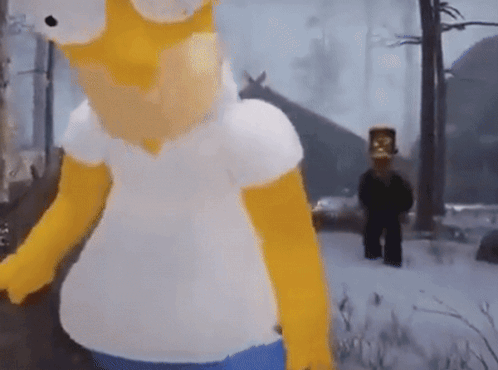 A Homer Simpson Mascot Is Standing In The Snow In Front Of A House GIF
