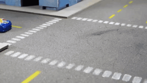 A Hot Wheels Car Is Driving Down A Street GIF