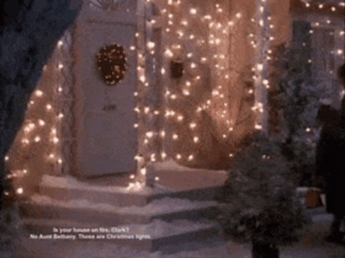 A House Is Decorated With Christmas Lights And A Wreath On The Front Door GIF