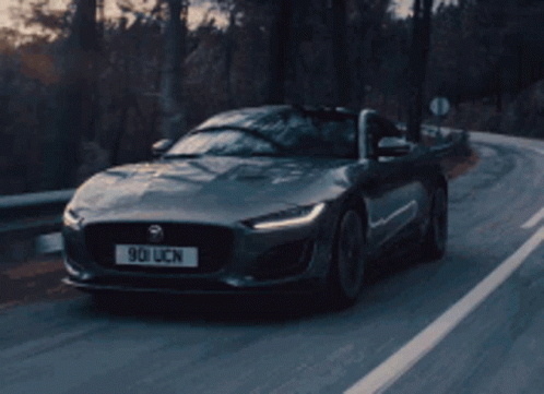 A Jaguar Is Driving Down A Road With A License Plate That Says 901 Ucn GIF