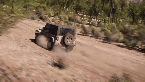 A Jeep Is Driving On A Dirt Road In The Desert . GIF