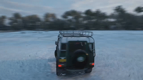 A Jeep Is Driving Through A Snowy Field With A License Plate That Says ' A ' On It GIF