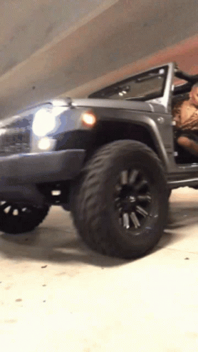 A Jeep Is Parked In A Garage With The Doors Open GIF