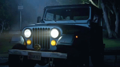 A Jeep Is Parked In Front Of A Sign That Says No Parking GIF