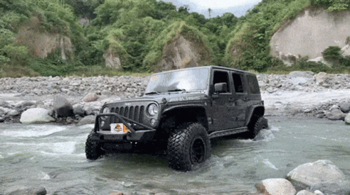 A Jeep With A License Plate That Says ' Jeep ' On It Is Driving Through A River GIF