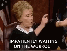 A Judge Is Sitting At A Desk And Pointing At Someone While Waiting On The Workout . GIF