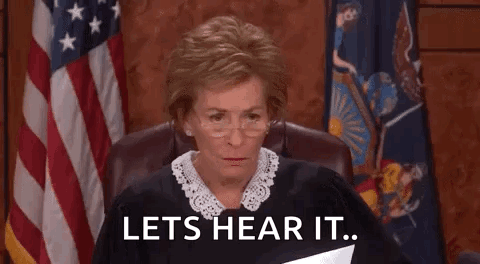 A Judge Is Sitting In A Courtroom Holding A Piece Of Paper And Says `` Lets Hear It '' . GIF