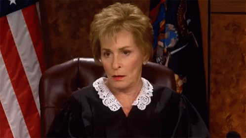 Judge Sitting In Front Of American Flag GIF