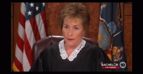 A Judge Sitting In Front Of An American Flag With Bachelor 10 Written On The Bottom GIF