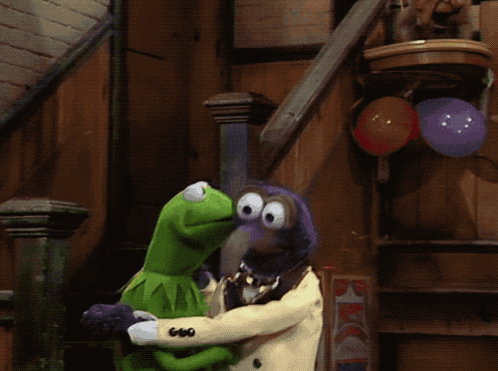 A Kermit The Frog And A Muppet Standing Next To Each Other With Balloons In The Background GIF