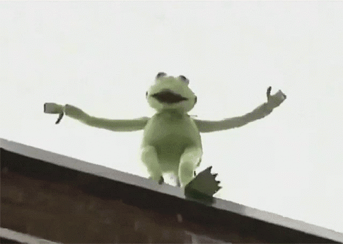 A Kermit The Frog Is Sitting On The Edge Of A Building . GIF