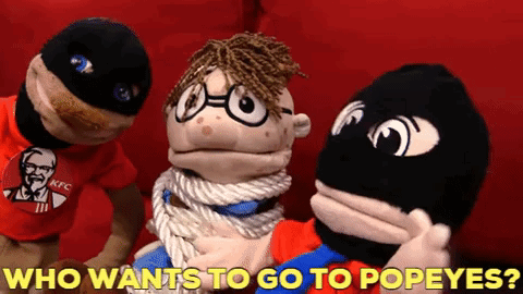 A Kfc Shirt Is On A Puppet With The Words Who Wants To Go To Popeyes Below It GIF