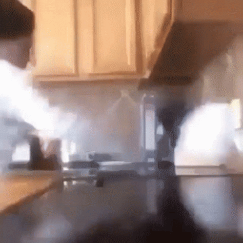 A Kitchen With Smoke Coming Out Of The Hood GIF