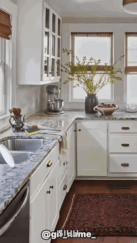 A Kitchen With White Cabinets And Granite Counter Tops And A Rug GIF