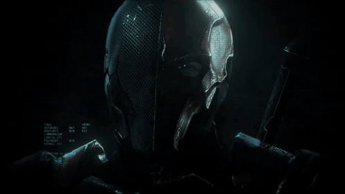 A Knight In Armor Is Holding A Sword In A Dark Room GIF
