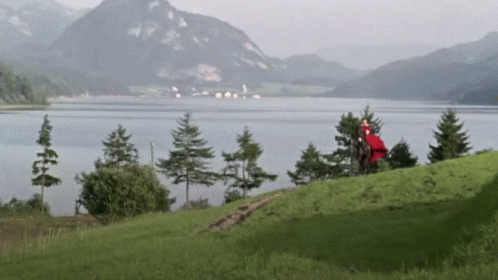 A Lake With Mountains In The Background And Trees On The Shore GIF