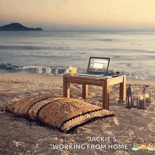 A Laptop Sits On A Small Table On The Beach With The Words Jackie 'S Working From Home GIF