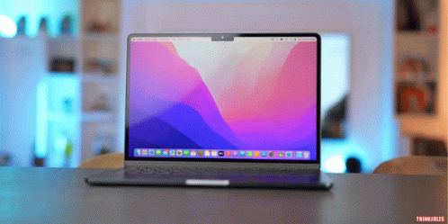 A Laptop With A Purple And Blue Screen Is Sitting On A Desk GIF