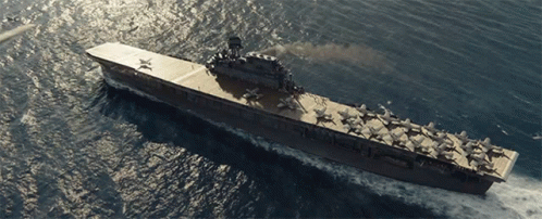 a large aircraft carrier is floating in the ocean with a few planes on the deck