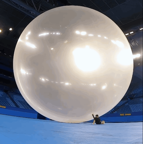 A Large Balloon In A Stadium With A Sign That Says Rio Arena On It GIF