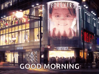 A Large Billboard On The Side Of A Building That Says `` Good Morning '' . GIF