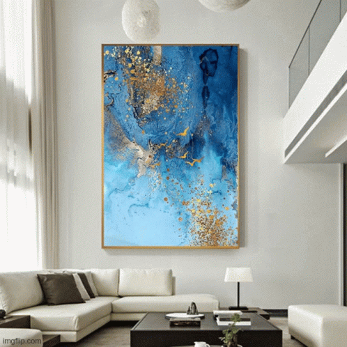 A Large Blue And Gold Painting Hangs Above A Couch GIF