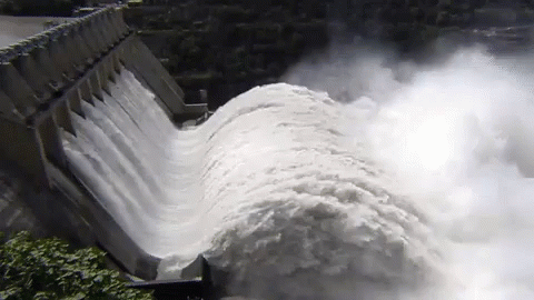 A Large Body Of Water Is Coming Down A Dam Wall GIF