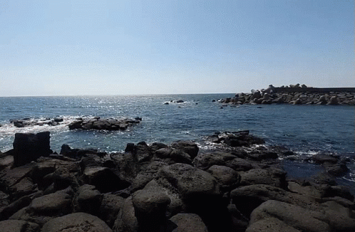 A Large Body Of Water Is Surrounded By Rocks GIF