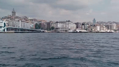 A Large Body Of Water Surrounded By Buildings With A City In The Background GIF