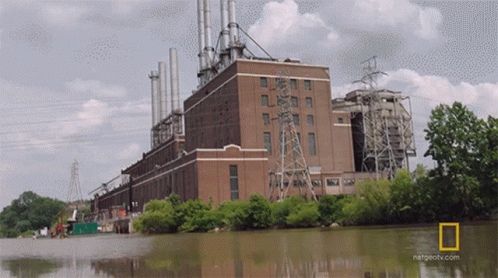 A Large Brick Building Next To A Body Of Water With A National Geographic Logo GIF