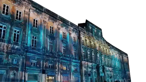 a large building with a lot of windows is lit up with blue and yellow lights