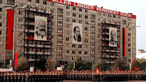 A Large Building With A Sign That Says " Aller Lander Vereinigt Euch " GIF