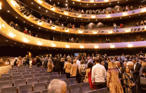 A Large Crowd Of People Are Gathered In A Large Theater GIF