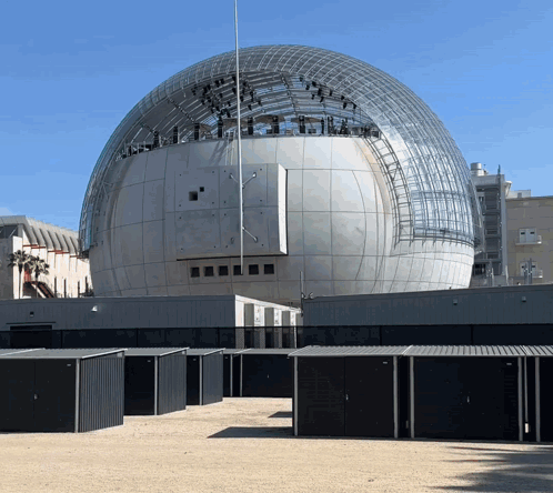 A Large Dome Shaped Building With A Sign That Says ' Academy Of Motion Picture Arts And Sciences ' On It GIF