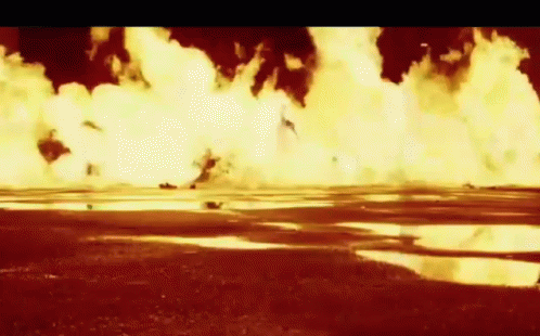 A Large Explosion In A Field With A Puddle In The Middle GIF