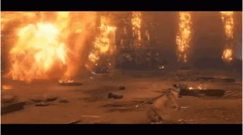 A Large Explosion Is Taking Place In A Field With A Lot Of Fire Coming Out Of It . GIF