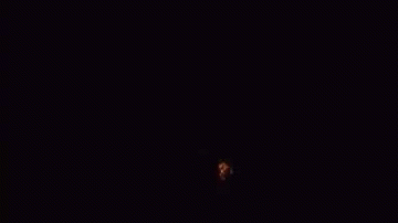 A Large Explosion Of Fire Is Coming Out Of The Ground In The Dark . GIF