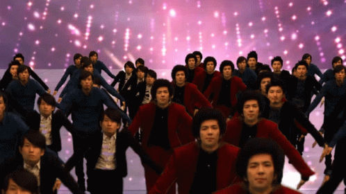 A Large Group Of People Are Dancing In Front Of A Purple Background GIF