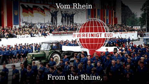 A Large Group Of People Are Gathered In Front Of A Sign That Says Vom Rhein From The Rhine GIF