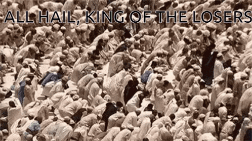 A Large Group Of People Are Kneeling Down In Front Of A Sign That Says All Hail King Of The Losers . GIF