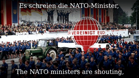 A Large Group Of People Are Marching In Front Of A Sign That Says " Es Schreien Die Nato-Minister " GIF