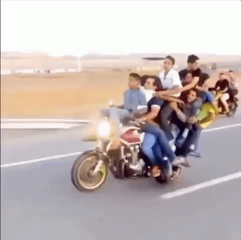 A Large Group Of People Are Riding Motorcycles Down A Road . GIF