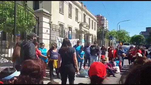 a large group of people are standing in front of a building on a street .