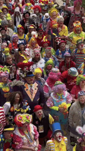 A Large Group Of People Dressed In Clown Costumes Including A Man Wearing A Red Shirt That Says ' Clown ' GIF