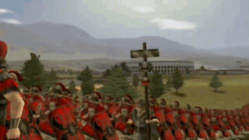 A Large Group Of Roman Soldiers Marching In A Field With Mountains In The Background GIF