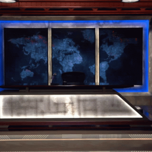 A Large Map Of The World Hangs On A Wall Above A Desk GIF