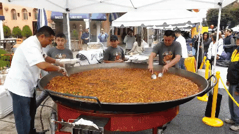 A Large Pan Of Food Is Being Cooked In Front Of A Bacca Lebanon Tent GIF